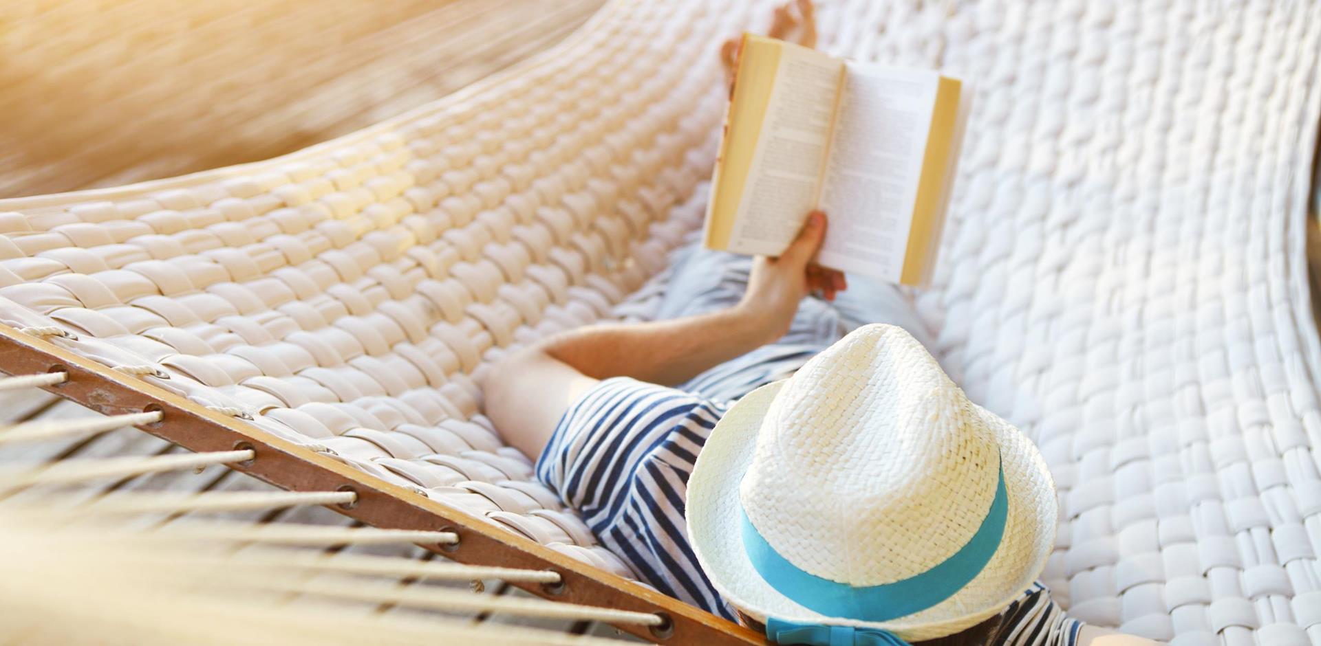 Man reading book on hammock, digital detox holidays